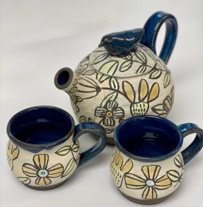 Pottery teapot and cups with flower design