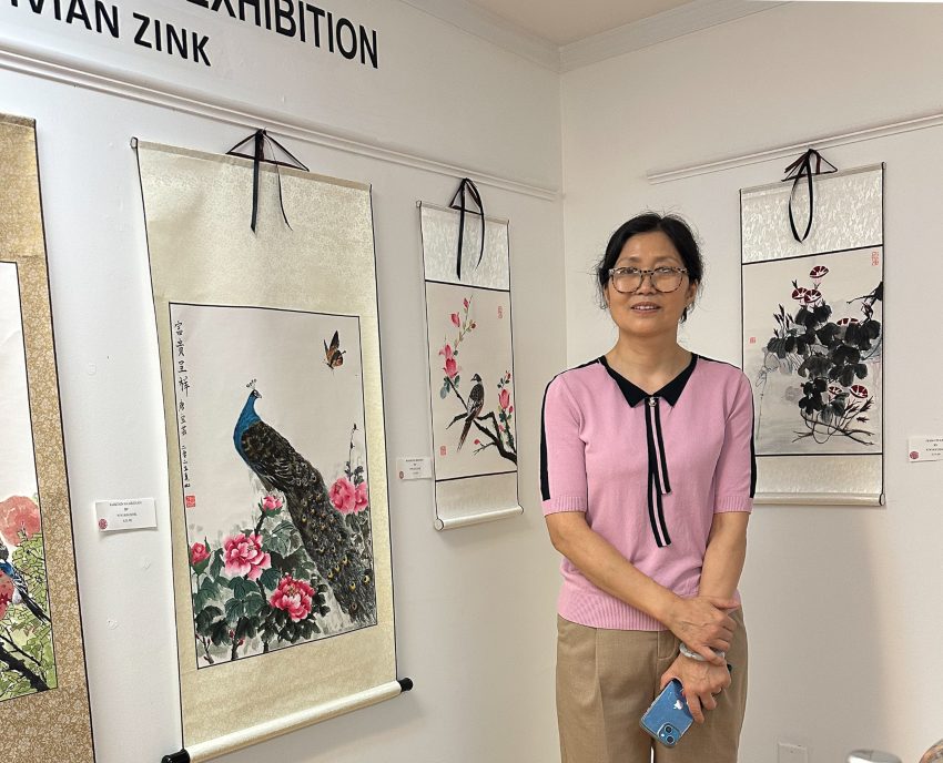 Vivian Zink Chinese woman wearing glasses in pink top with black trim